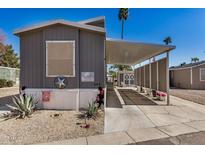 Charming mobile home exterior with covered parking and desert landscaping at 201 S Greenfield Rd # 254, Mesa, AZ 85206