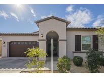 View of home exterior featuring an arched entry way, low maintenance landscaping and a brown garage door at 2049 W Burnside W Trl, Phoenix, AZ 85085