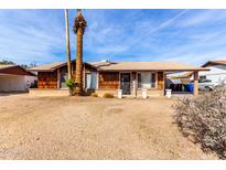 Cozy single-story house with a wood facade, desert landscaping, and a carport at 3262 E Enid Ave, Mesa, AZ 85204