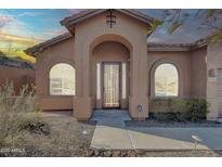 Charming home featuring a covered entrance, arched windows, and desert landscaping at 4365 S Columbine Way, Gold Canyon, AZ 85118
