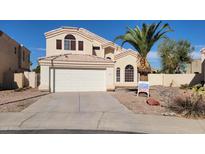 Charming two-story home with a two-car garage, desert landscaping, and a lush palm tree in the front yard at 62 N Amber Ct, Chandler, AZ 85225