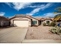 Charming single-story home showcasing a desert landscape, tile roof, and attached two-car garage, creating curb appeal at 1210 E Flint St, Chandler, AZ 85225