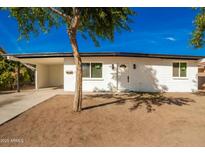 Charming single-story home featuring a crisp white exterior, covered parking and a well-maintained yard at 1254 W Manhatton Dr, Tempe, AZ 85282