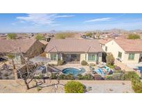 Expansive aerial view of backyard, showcasing pool, patio furniture, and desert landscaping with mountain views at 15313 S 180Th Ave, Goodyear, AZ 85338