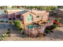 Stunning elevated view of the pink-hued home featuring a private pool and fenced yard at 15865 E Lost Hills Dr, Fountain Hills, AZ 85268
