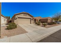 Charming single-story home with a well-manicured lawn and a spacious two-car garage at 17168 W Saguaro Ln, Surprise, AZ 85388