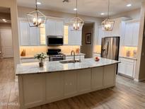 Bright kitchen features granite counters, a stainless steel refrigerator, and a large center island with pendant lighting at 41553 W Springtime Rd, Maricopa, AZ 85138