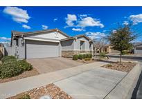 Charming single-Gathering home featuring a manicured lawn, stone accents, and a two-car garage at 10726 E Tallahassee Ave, Mesa, AZ 85212