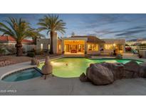 Stunning backyard pool with rock features, spa, and covered patio, perfect for outdoor entertaining at 10810 E San Salvador Dr, Scottsdale, AZ 85259