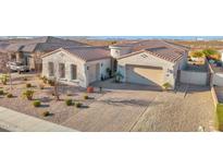 Inviting home showcasing a tile roof, a neutral stucco facade, and a spacious driveway at 14562 W Georgia Ave, Litchfield Park, AZ 85340