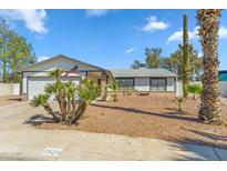 Charming single-story home with desert landscaping, an American flag, and a two-car garage at 2920 E Villa Maria Dr, Phoenix, AZ 85032