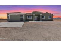 Charming one-story home with a modern garage door and a large, sunny front yard at 40715 W Georgia Ave, Tonopah, AZ 85354