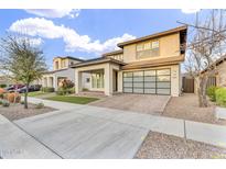 Stylish two-story home boasts a modern design, neutral colors, and a unique glass-paneled garage door at 4741 S Avitus Ln, Mesa, AZ 85212