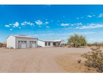 Wide exterior view of a home and detached garage in a desert environment at 53040 W Whirly Bird Rd, Maricopa, AZ 85139