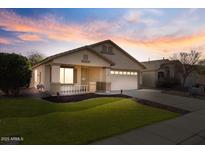 Charming single-story home featuring a well-maintained lawn and a welcoming front porch at sunset at 6121 S Ruby Dr, Chandler, AZ 85249