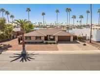 Charming waterfront home featuring desert landscaping, brick driveway and plentiful palm trees at 9945 W Cameo Dr, Sun City, AZ 85351