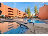 Inviting outdoor pool and spa with waterfall feature, surrounded by stylish architecture and lounge seating at 12222 N Paradise Village S Pkwy # 224, Phoenix, AZ 85032