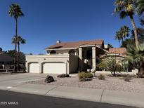 Charming two-story home featuring a three-car garage, desert landscaping, and palm trees at 1302 E Tierra Buena Ln, Phoenix, AZ 85022