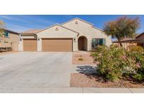 Charming single-story home featuring a three-car garage, desert landscaping, and a neutral color palette at 17462 W Straight Arrow Ln, Surprise, AZ 85387