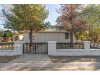 Charming single-story home with a decorative fence and mature trees in the front yard at 1933 W Ocotillo Rd, Phoenix, AZ 85015