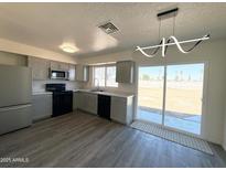 An open kitchen features stainless steel appliances, grey cabinets and a sliding glass door to the outside patio at 2018 W Western Dr, Chandler, AZ 85224