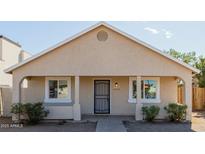 Charming single-story home featuring a welcoming front porch and a neutral color palette at 2033 W Adams St, Phoenix, AZ 85009