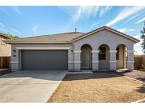 Charming single-story home featuring an attached garage, neutral colors and a well-manicured front yard at 21333 N Denton Dr, Maricopa, AZ 85138