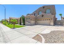 Attractive home featuring a three car garage, neutral color palette, and well manicured lawn at 2453 E Ebony Dr, Chandler, AZ 85286