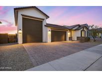 Charming single-story home with a three-car garage and stylish desert landscaping at 25658 N 140Th Ln, Surprise, AZ 85387