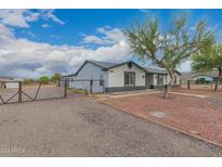 Charming gray single story home with stone accents, mature trees, and gravel driveway at 25723 S Hawes Rd, Queen Creek, AZ 85142