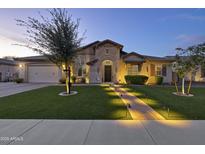 Charming home featuring a manicured lawn, desert landscaping and illuminated walkway at 2882 E Wildhorse E Dr, Gilbert, AZ 85297