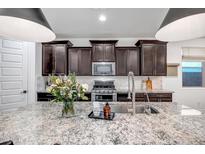 Stylish kitchen with a large granite island, stainless steel appliances and dark cabinetry at 3010 W Laredo Ln, Phoenix, AZ 85085