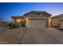 Inviting home exterior featuring a two-car garage, desert landscaping, and well-maintained facade at 44922 W Alamendras St, Maricopa, AZ 85139