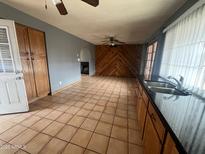 An expansive living area featuring wood paneling, tile floors, and abundant natural light at 4537 E Hidalgo Ave, Phoenix, AZ 85040