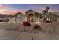 Charming home featuring a three-car garage, desert landscaping, and mature palm trees, ideal for curb appeal at 7538 E Forge Ave, Mesa, AZ 85208