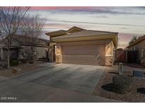 Charming single-Gathering home featuring a two-car garage and stone accents at 8003 S 69Th Dr, Laveen, AZ 85339