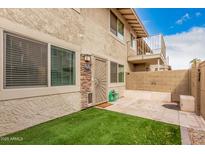 Cozy backyard with artificial turf, block wall, and hardscaped patio, perfect for outdoor living at 8532 E Belleview St, Scottsdale, AZ 85257