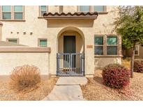Inviting entryway with gated access, light-colored stucco, and an arched entrance to the front door at 14870 W Encanto Blvd # 1008, Goodyear, AZ 85395