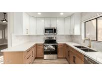 Modern kitchen features stainless steel appliances, white cabinets, and quartz countertops at 15050 N Thompson Peak Pkwy # 2036, Scottsdale, AZ 85260