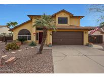 Charming home with a brown two-car garage and mature landscaping, including a palm tree at 15237 N 61St Dr, Glendale, AZ 85306