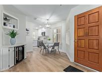 Stylish dining area featuring modern light fixture, white kitchen and charming bar at 19400 N Westbrook Pkwy # 241, Peoria, AZ 85382