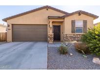 Charming single-story home with stucco exterior, stone accents, desert landscaping, and two-car garage at 2292 S 236Th Dr, Buckeye, AZ 85326