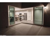 A modern, open kitchen with stainless steel appliances viewed from the outdoor patio through sliding glass doors at 44428 W Palo Teca Rd, Maricopa, AZ 85138