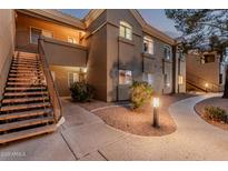 Charming condo exterior featuring a well-lit walkway and inviting staircase to upper units at 5335 E Shea Blvd # 2102, Scottsdale, AZ 85254