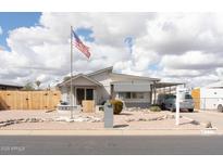 Charming single-story home featuring a landscaped front yard and an American flag at 614 S 92Nd Pl, Mesa, AZ 85208