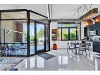 Bright living room featuring large windows, sleek floors, and modern decor leading into the kitchen at 7301 E 3Rd Ave # 121, Scottsdale, AZ 85251