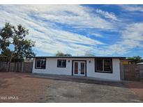 Inviting single-story home with a freshly painted exterior, enhancing its curb appeal and complemented by the beautiful sky at 770 S Pinal Dr, Apache Junction, AZ 85120
