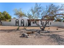 Charming home featuring desert landscaping, mature trees, and a decorative rock garden at 7713 E Mawson Rd, Mesa, AZ 85207