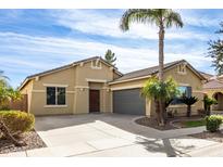Charming home featuring a well-manicured lawn, a spacious driveway, and a desert-style landscape with a mature palm tree at 869 E Waterview Pl, Chandler, AZ 85249