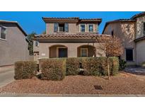 Charming two-story home featuring a tile roof, arched entryway, and well-maintained landscaping in a residential neighborhood at 10938 W Pierson St, Phoenix, AZ 85037